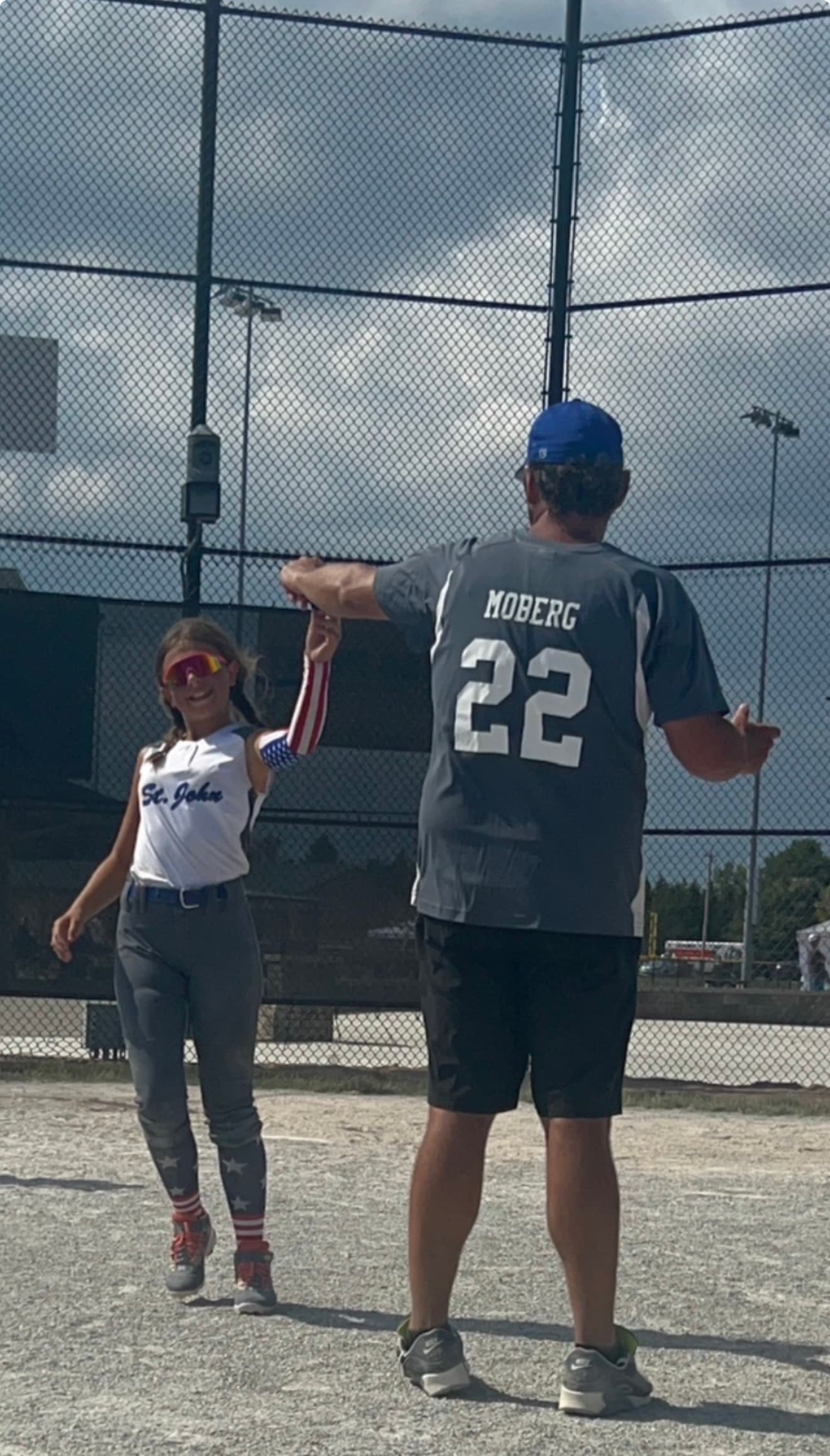 Coach Mo celebrating with a young softball athlete on the field