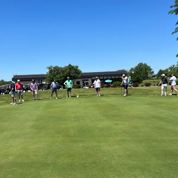Golfers warming up on the green by the clubhouse