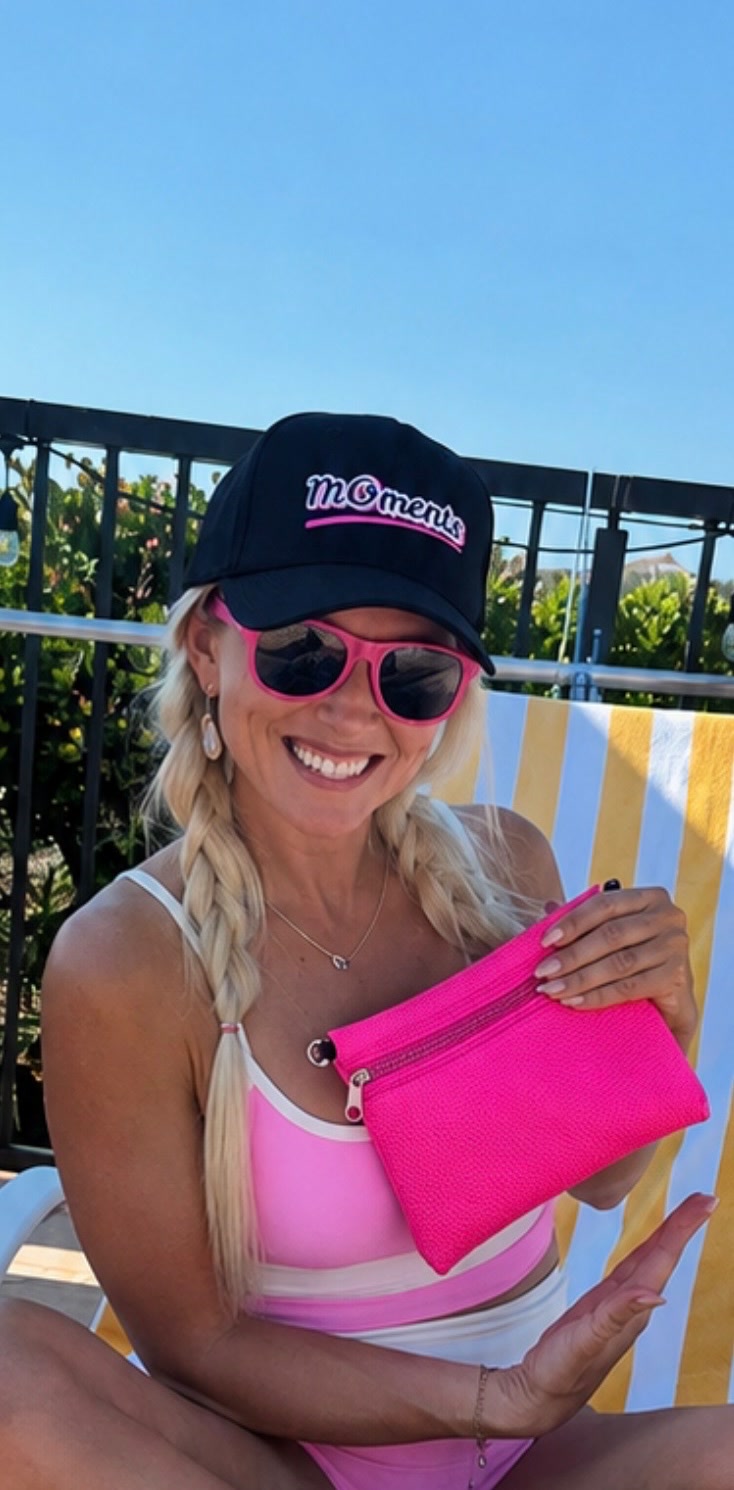 A supporter in a MOments hat with bright pink accessories