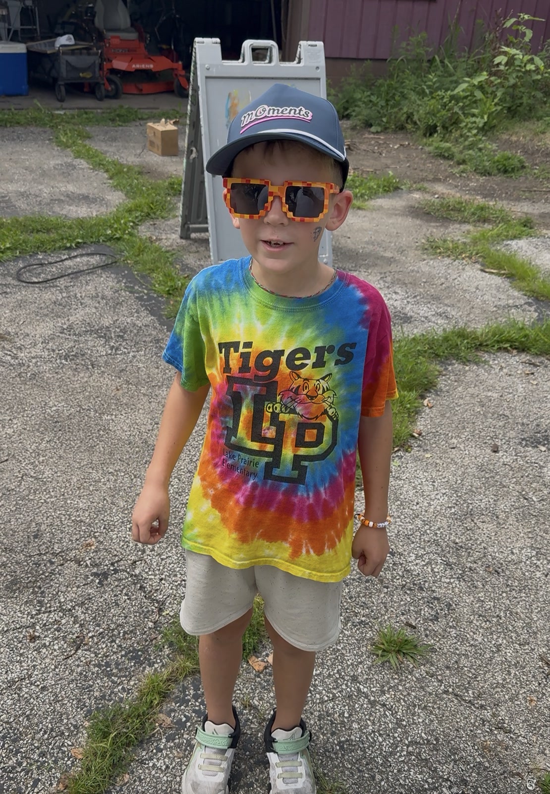 A young supporter wearing a MOments hat and colorful sunglasses