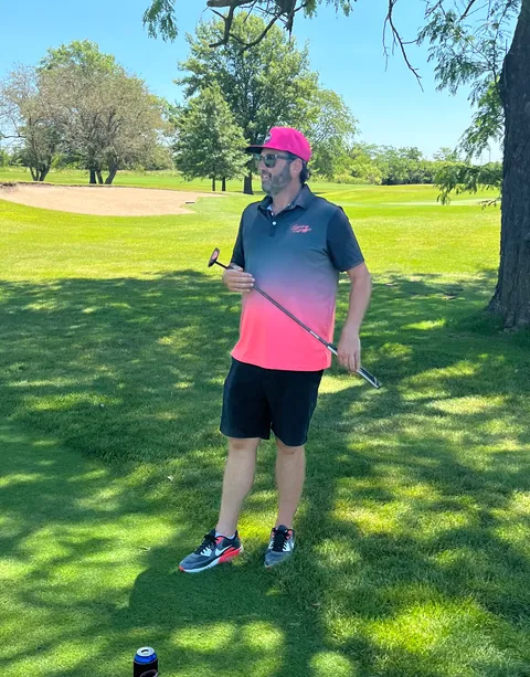 A golfer in MOments gear lining up a shot on the course